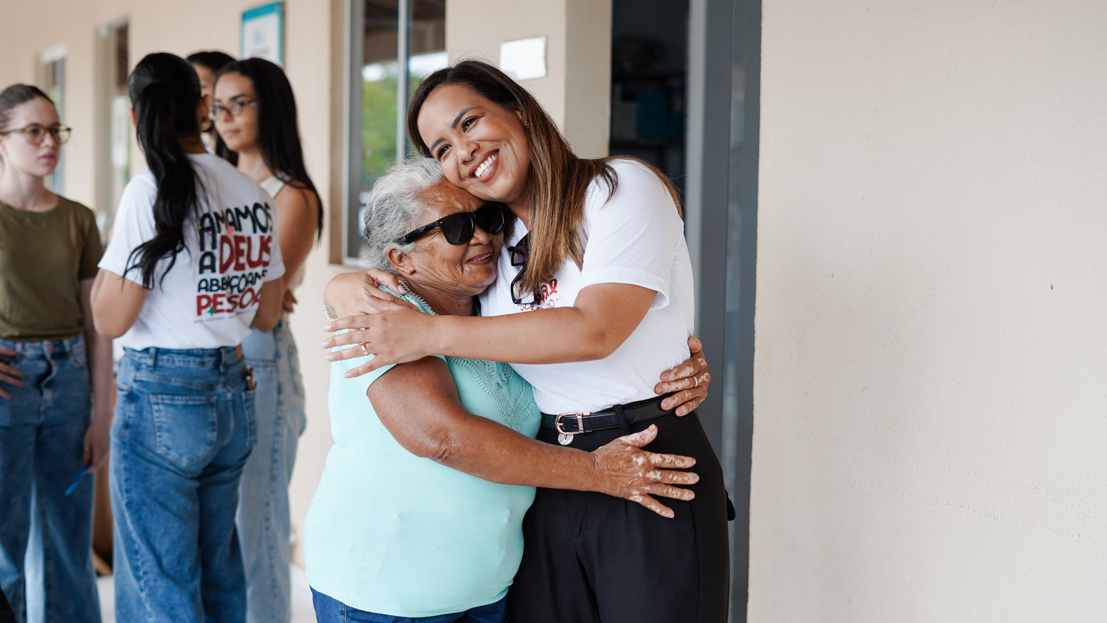 Voluntária abraçando uma participante em uma ação do instituto